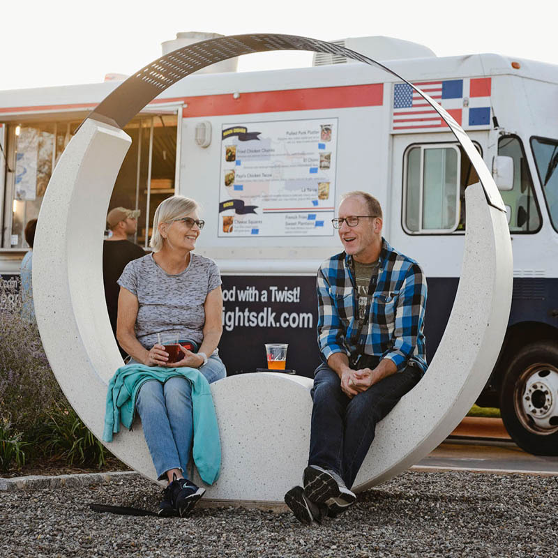 couple sits on an art installation during an event at Mosaic